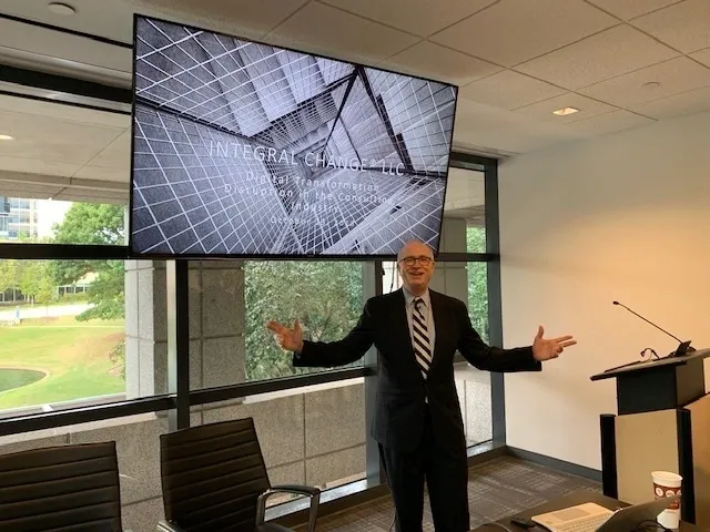 a man in a black suit giving a presentation